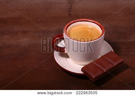 Coffee cup and chocolate on wooden table texture. Coffeebreak.