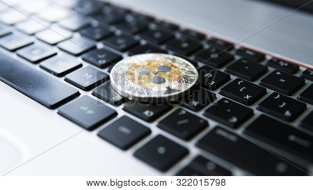 Silver Gold Ripple Coin On A Laptop Keyboard Closeup. Blockchain Mining. Digital Money And Virtual C