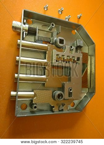 Fixing Device - Mortise Mechanical Door Lock Disassembled On An Orange Background