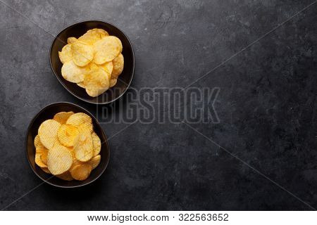 Beer snacks on stone background. Potato chips. Top view with copy space
