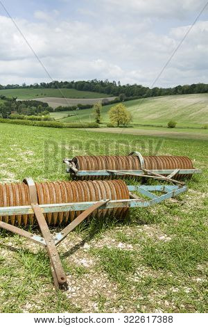 Agriculture Scene In England, Uk. Englis Farmland With A Plough (cambridge Roller Or Cultipacker) In