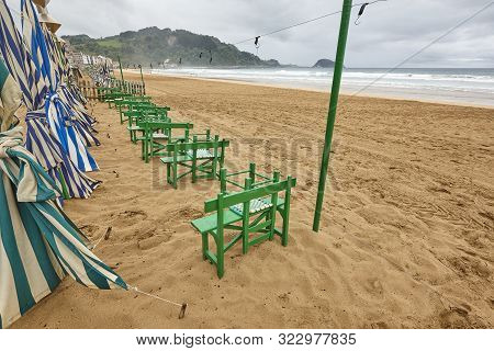 Zarautz Village Sand Beach With Umbrellas Cloudy Day. Euskadi, Spain