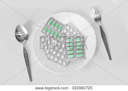Different Pills On A Plate With Cutlery. The Concept Of Prescription Drugs For Weight Loss. Means Fo