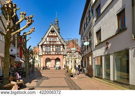 Hofheim, Germany - March 2021: Street with traditional half timbered buildings in old historic city center of Hofheim full of people on sunny day