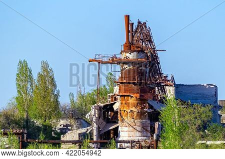 Rusty Metal Structures Of An Abandoned Factory Overgrown With Green Plants