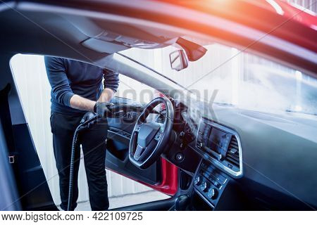 Car Service Worker Cleans Interiror With Steam Cleaner