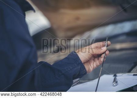 Car Mechanic Man Hand Checking Dipstick Engine Oil Car Mechanical On Site Service. Close Up Hand Man