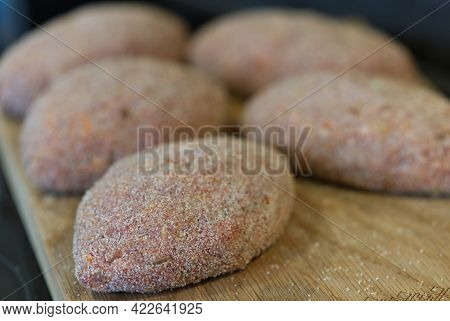 Raw Cutlets Made Of Ground Beef Meat On A Rustic Chopping Board. Homemade Cutlets