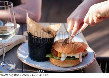People Sit In The Bar And Eat Juicy Burgers With Wine And Beer