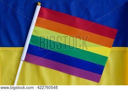 Lgbt Flag Against The Background Of The Flag Of Ukraine. Lgbt Pride Month. Lgbtqia. Close Up. Top Vi