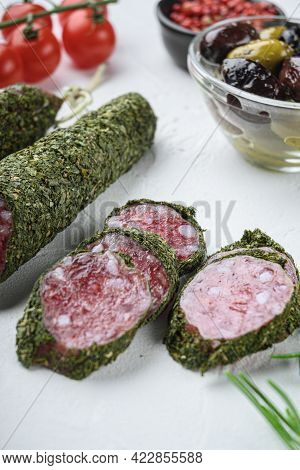 Traditianal Fuet Sausage In Herbs With Ingredients On White Textured Background.