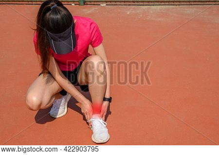 Woman Runner Kneel Down, Suffering From Ankle Pain. Ankle Pain May Be Caused By An Injury, Like A Sp