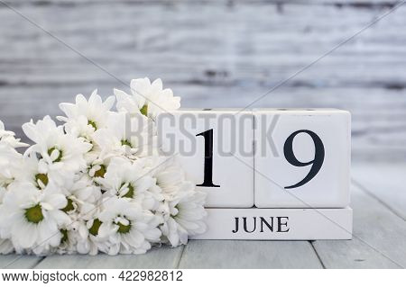 Juneteenth White Wood Calendar Blocks With The Date June 19th And White Daisies. Selective Focus Wit