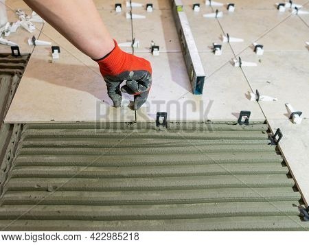 Workers Hands With Ceramic Tiles And Tools For Tiler. Floor Tiles Installation. Ceramic Tile Floor A