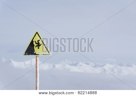 danger steep cliff mountain sign, mountains and cloudy sky
