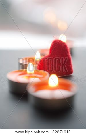 Red heart among burning candles for Valentine's Day