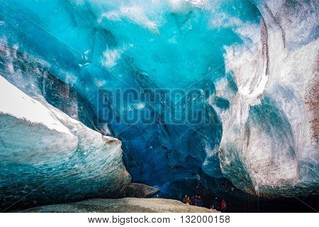 An amazing glacial ice cave entrance with travelers in Iceland