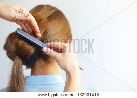 Professional female hairdresser making hairstyle to young woman with long hair. Babette hairstyle . Fashion concept