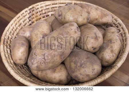 Closeup woven indigenous basket filled with raw whole Idaho russet potatoes