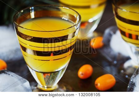 Traditional alcoholic cocktail of sea buckthorn berries on a granite background. Alcoholic beverages from different countries. Pernicious drinks. Selective focus
