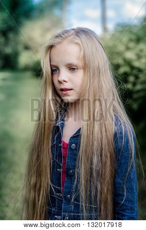 Portrait of a beautiful blonde little girl with long hair
