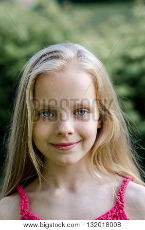 Portrait of a beautiful blonde little girl with long hair