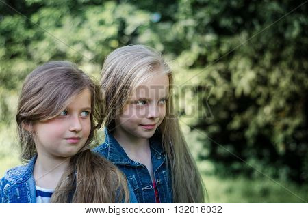 Portrait of two cute little girls enjoying summer outdoors.