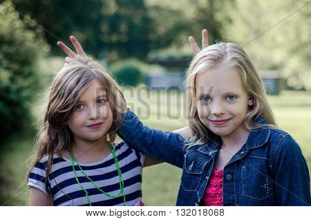Portrait of two cute little girls enjoying summer outdoors.