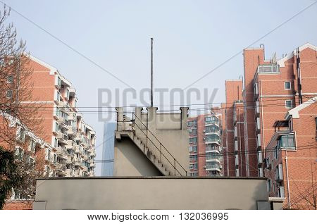 Entrance into and tower above it at the Longhua Martyr's cemetery with brick apartment buildings in the background.