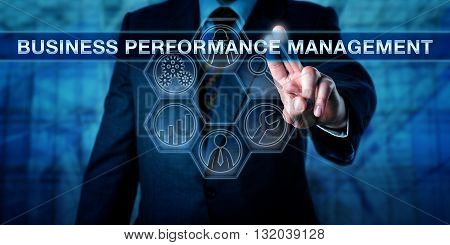 Manager is pressing BUSINESS PERFORMANCE MANAGEMENT on an interactive touch screen interface. Technology concept and business performance management metaphor with tool icons for analytic processes.