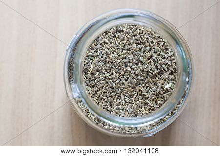 Glass jar with anise over wooden surface. Selective focus. High angle view