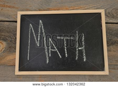 Math written in chalk on a chalkboard on a rustic background