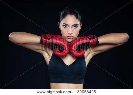 Beautiful fitness woman posing with bloxing gloves on black background