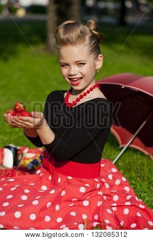 Pin-Up. Lovely little girl in the retro red dress in summer park