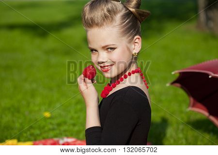 Pin-Up. Lovely little girl in the retro red dress in summer park