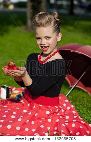 Pin-Up. Lovely little girl in the retro red dress in summer park
