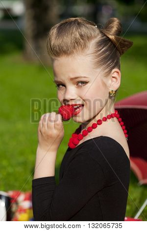 Pin-Up. Lovely little girl in the retro red dress in summer park