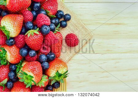 Strawberry and mix berry on wooden background top view