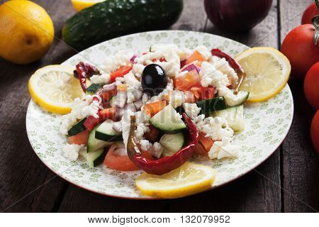 Shopska salad with cheese, olives, cucumber, tomato and chili peppers