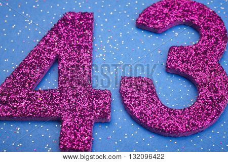 Number fortythree purple color over a blue background. Anniversary. Horizontal