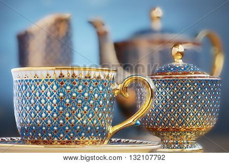 Thai fine art traditional five colors (Bencharong) tea cup over blue blurry background.
