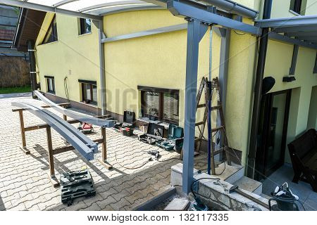 Building a canopies on a residential house. Building a metal construction for residence shading.