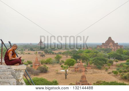 Bagan Myanmar - April 22 2016 : Monk siting on the top of Shwesandaw Pagoda to view the sunset