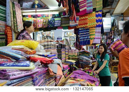 Yangon Myanmar - April 26 2016 : People buying traditional burmese clothes in a clothes shop in Bogyoke market