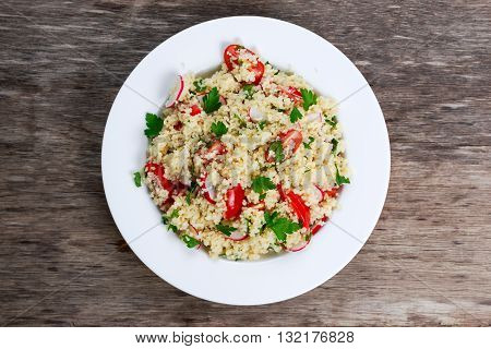 Homemade Fresh Couscous salad with vegetables, in white plate