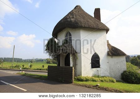 Hexagonal two-storey thatched toll house built around 1793 and served as a toll house when turnpikes were in use. A pouch hung on a hook over the door was used by coach drivers to pay the toll.