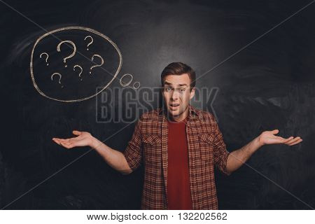 Attractive Young Freelancer At A Loss On The Background Of Chalkboard