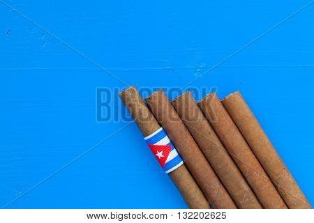 Detail of luxury Cuban cigars on the blue desk