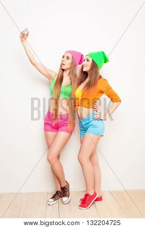 Two Pretty Hipster Girls Shooting On Mobile Phone