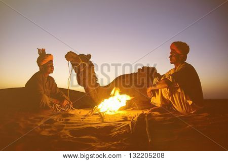 Two Indigenous Indian Men Resting By The Bon Fire Camel Concept